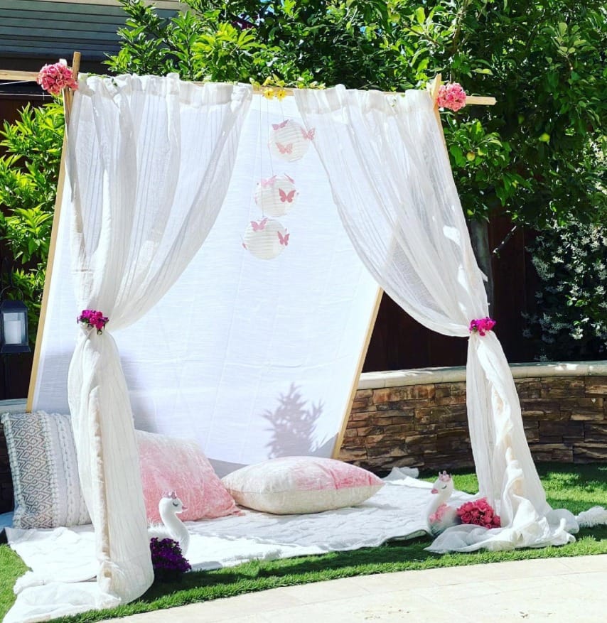 Special Events, a romantic setting for two of an outdoor covering with sheers and pillows by Mellow Events